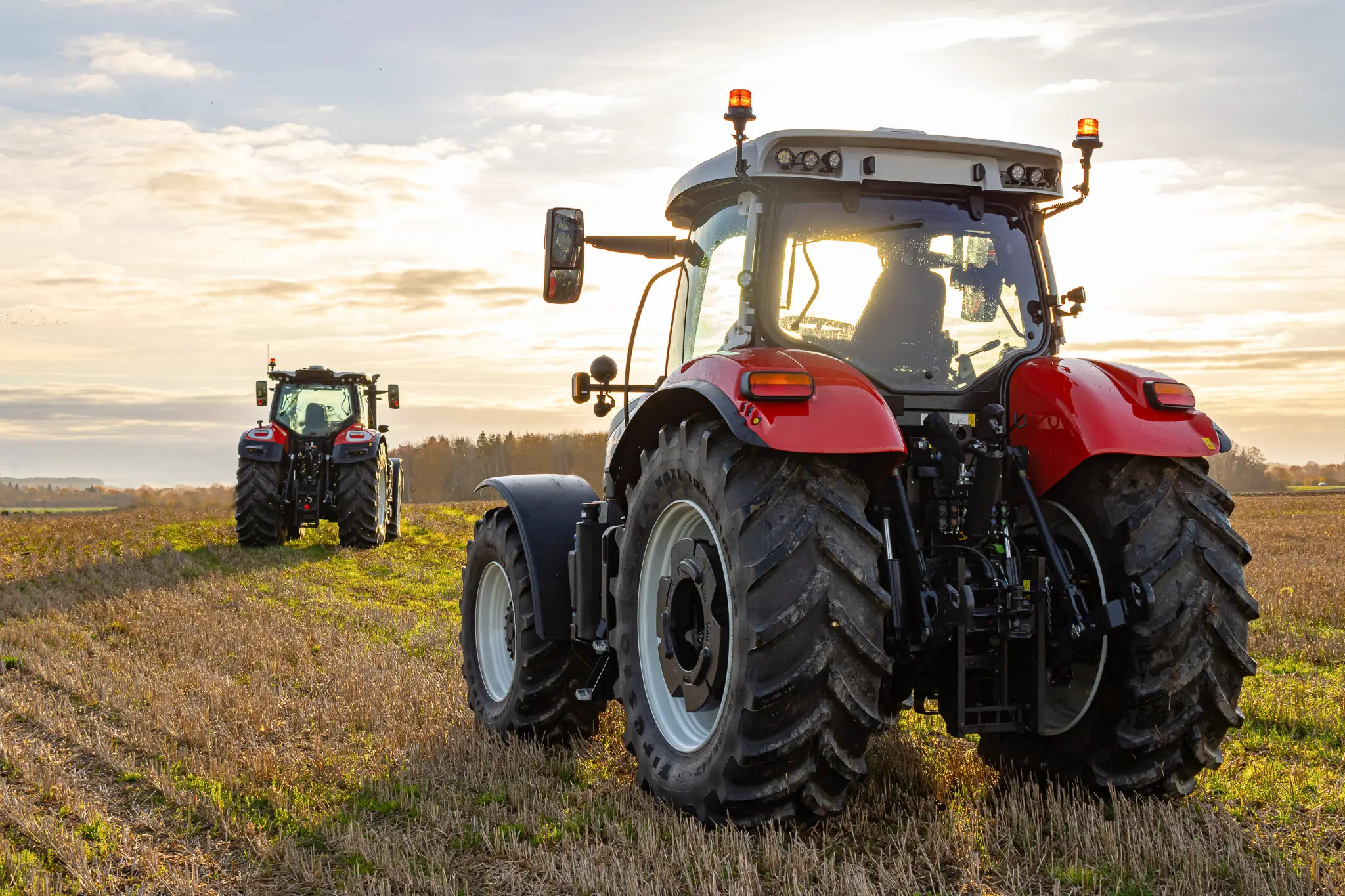 Tractors in a Field Facing Sunset